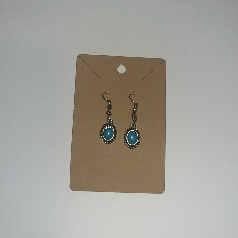 Vintage looking handmade dangly earrings with a blue stone in the center